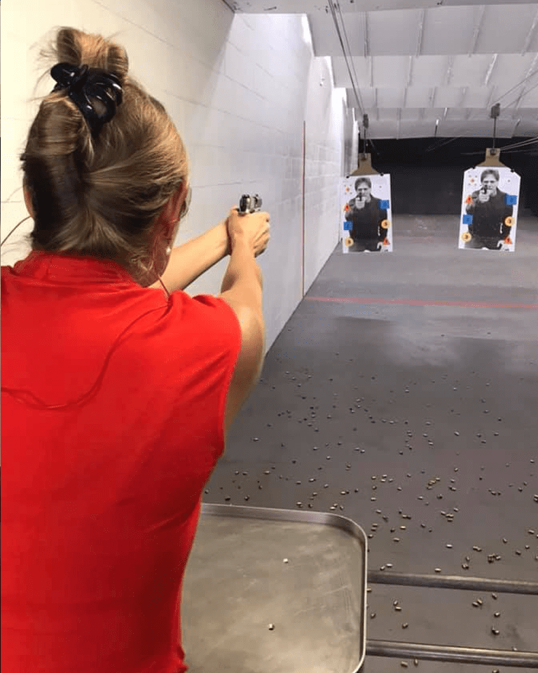 A woman practicing some target shooting on the range.